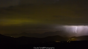 Paysages des Alpes, orage du 12 Aout 2021, coup de foudre proche du col d&lsquo;Ornon 38, à G les lumières de la ville de La Mure éclairent le ciel.